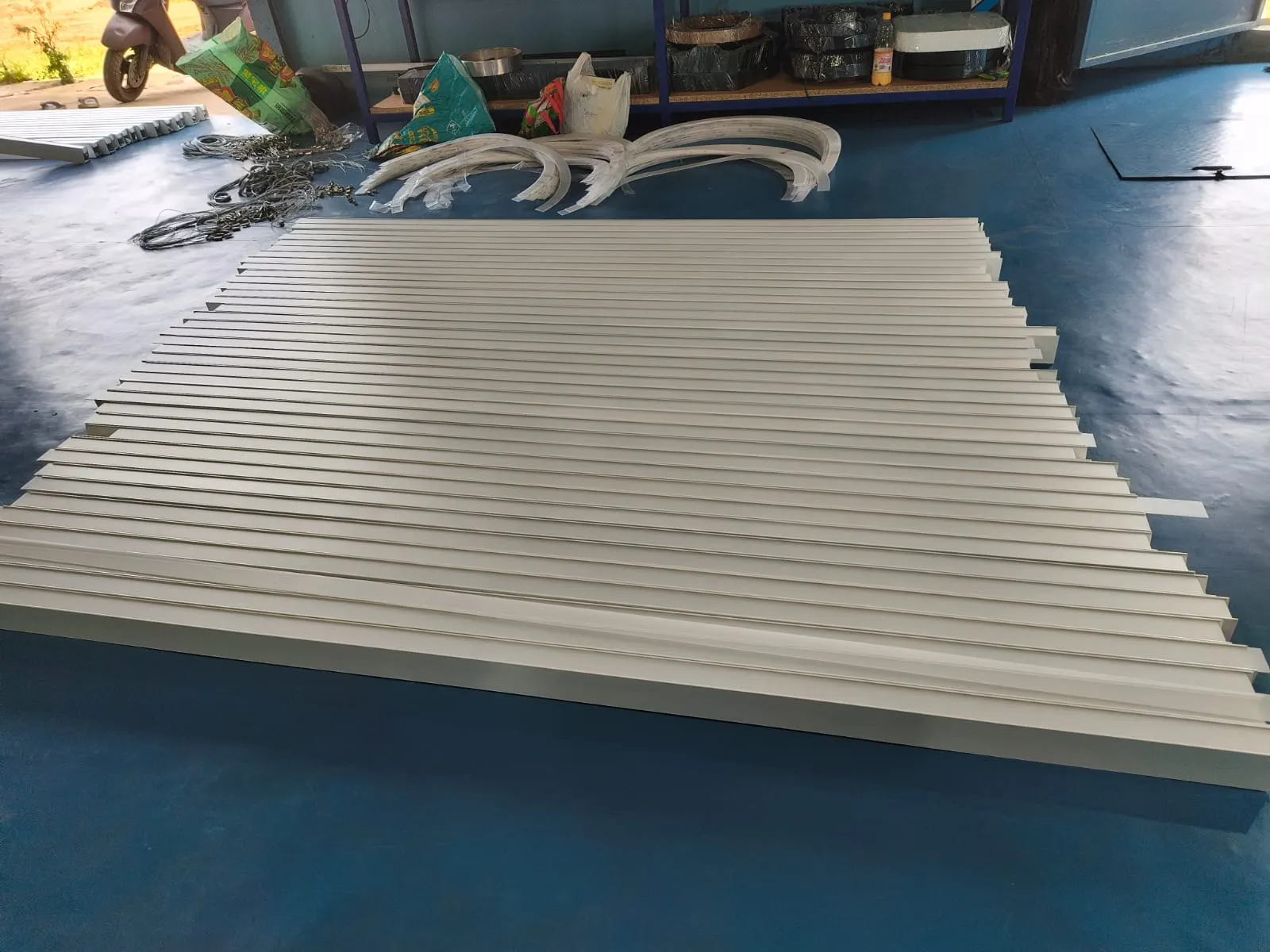 Batch of white linear aluminium profiles and curved diffusers in production