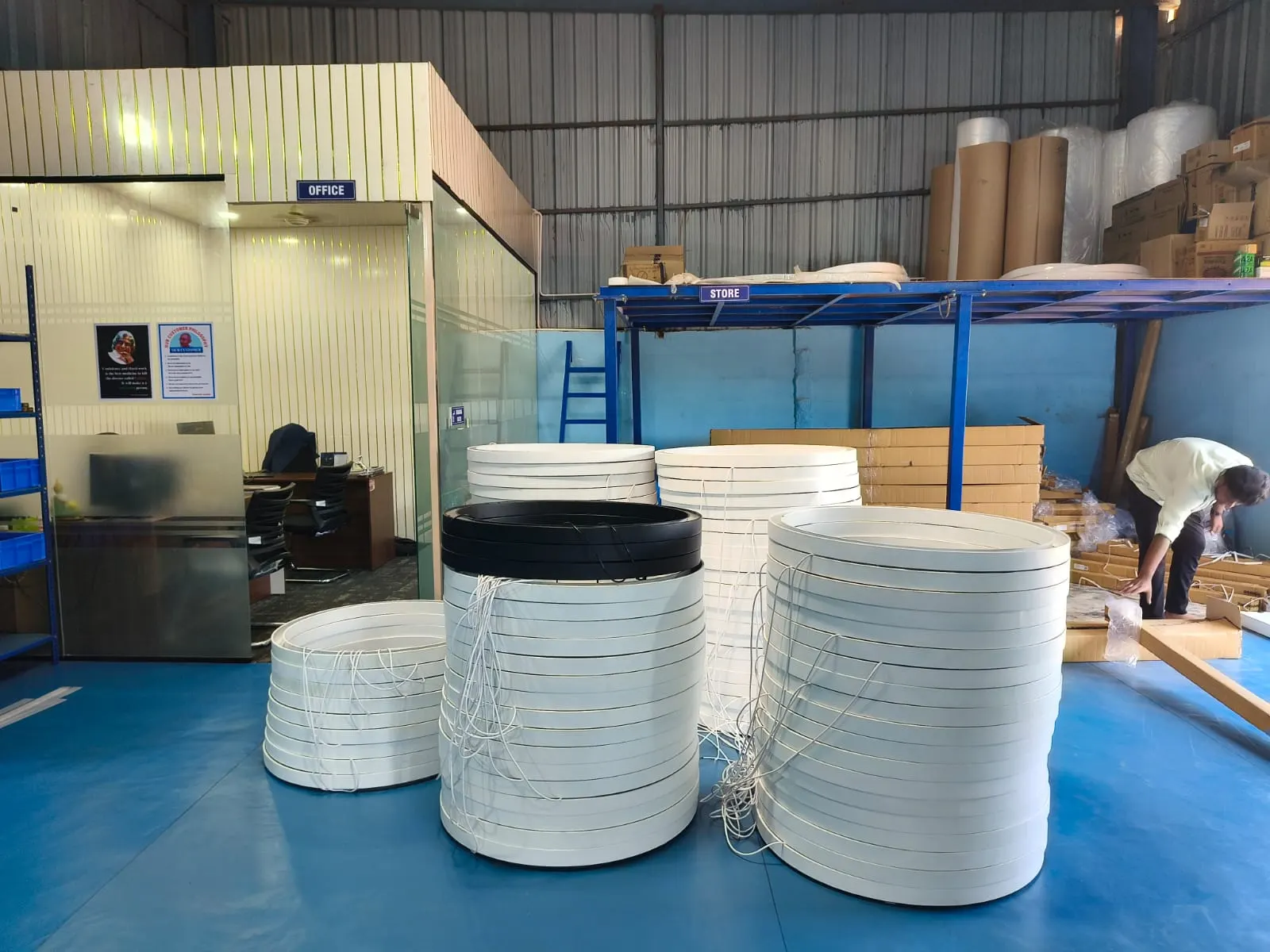 Stacks of finished white and black ring luminaires at the G Tech Lights workshop