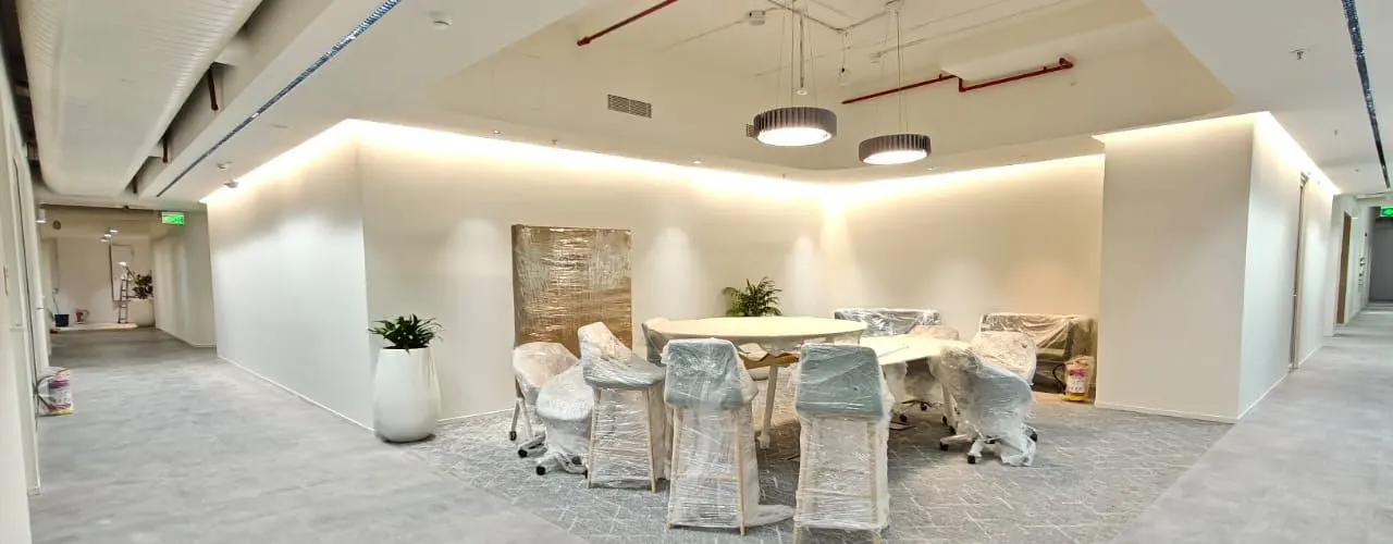 Collaboration area with concealed cove lighting washing the walls and two drum pendants