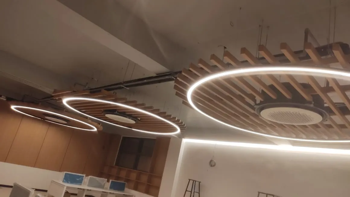 Three large ring profile lights beneath timber baffle rafts
